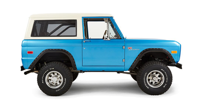 Side profile of Classic Ford Bronco blue with white hardtop, isolated on white background.