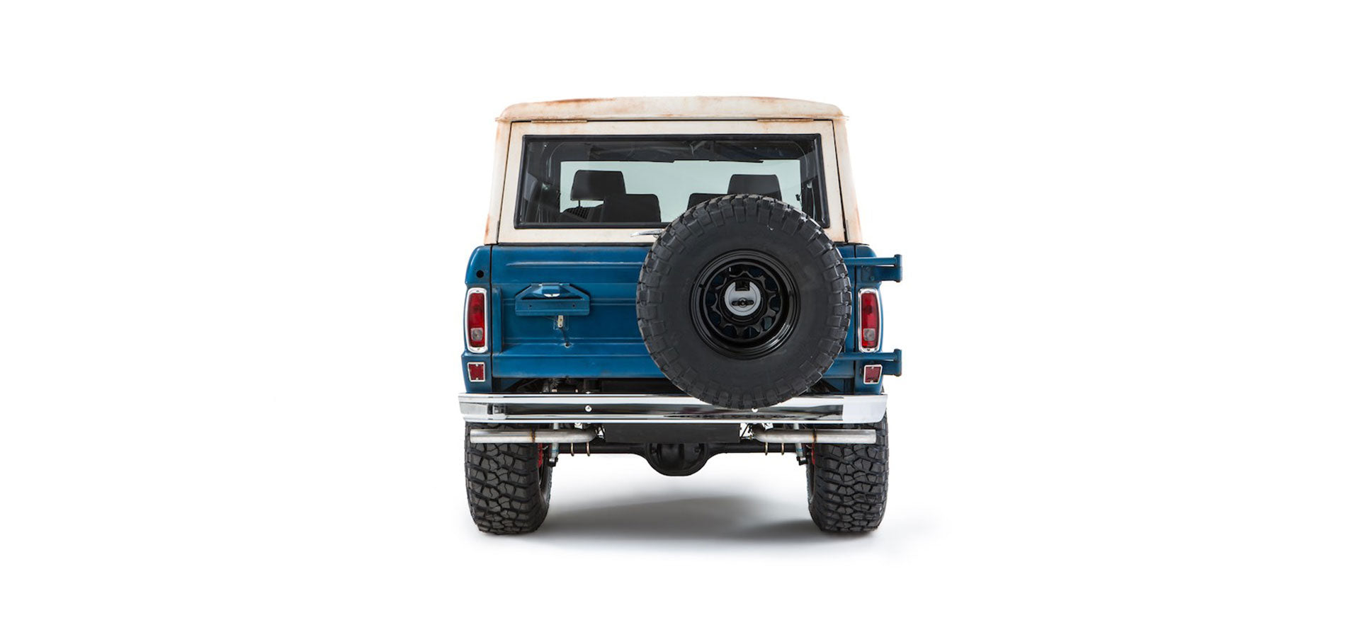 Rear view of a blue and white Classic Ford Bronco with spare tire mounted on tailgate