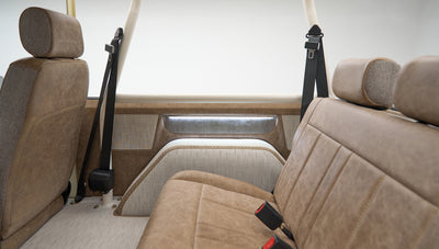 Rear interior view of Classic Ford Bronco showing brown seats and beige side panels