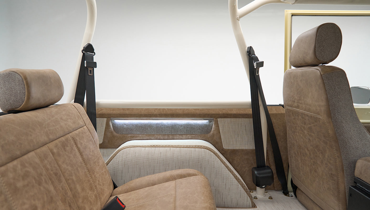 Rear interior seats of Classic Ford Bronco with tan upholstery and black seat belts