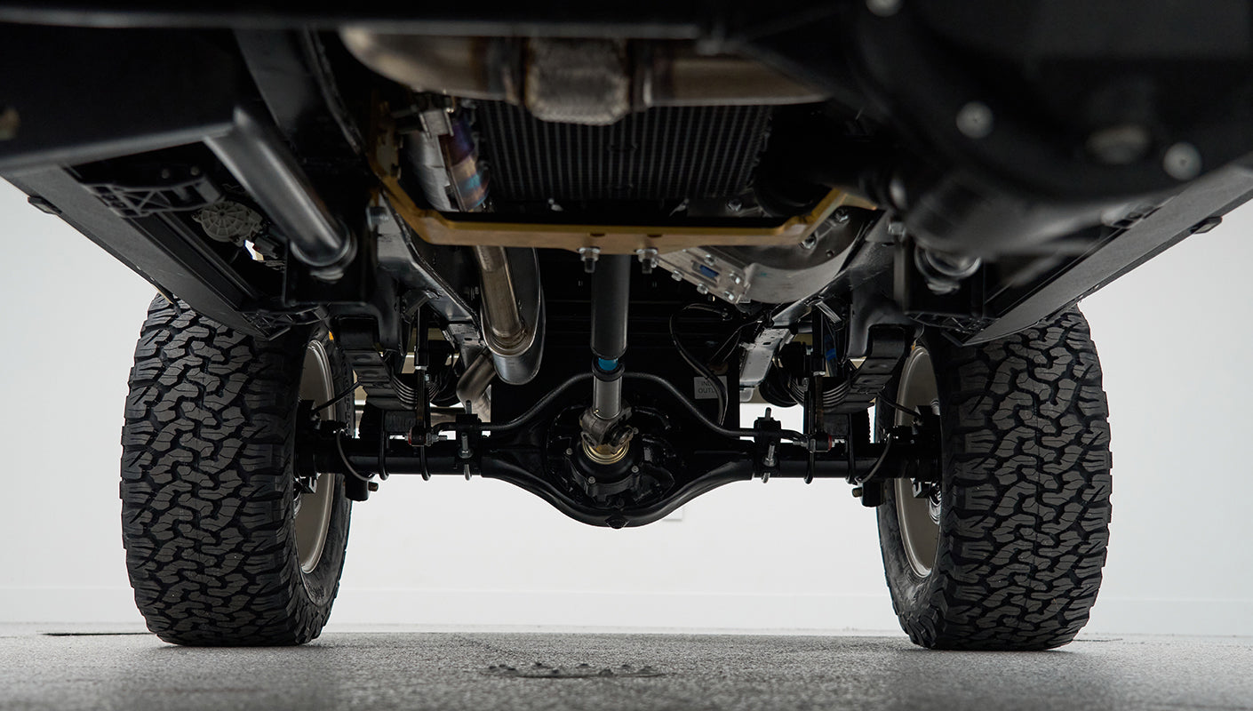 View of the rear underside suspension components and tires of Classic Ford Bronco