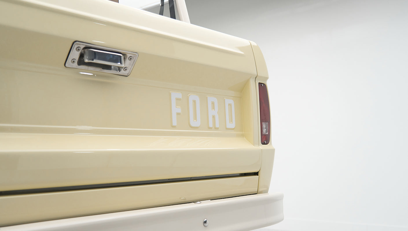 Rear tailgate of Classic Ford Bronco with white FORD lettering on cream paint