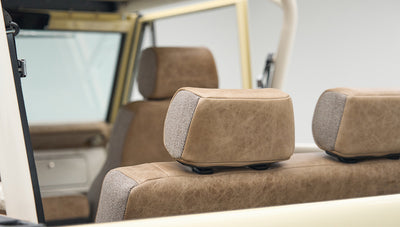 View of front and rear tan upholstered seats with headrests inside Classic Ford Bronco