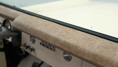 Beige leather dashboard padding of Classic Ford Bronco above control panel and air vents