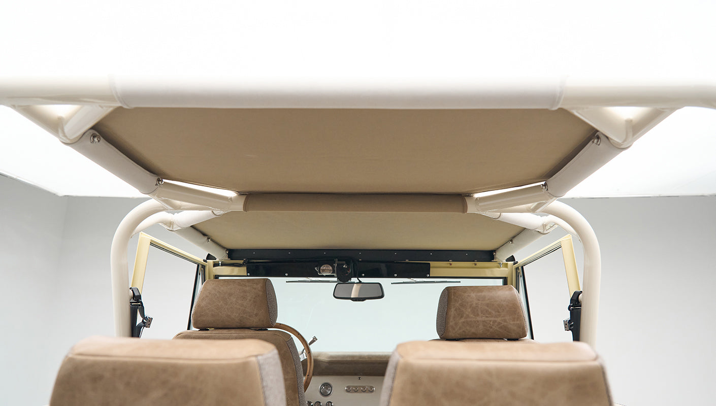 Rear view of beige leather and fabric seat headrests inside Classic Ford Bronco