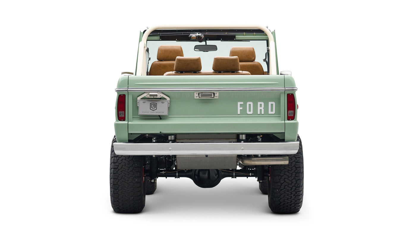Rear view of porcelain green Classic Ford Bronco with raised suspension and FORD lettering on tailgate