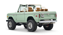 Rear and side view of green Classic Ford Bronco convertible showing tailgate with FORD lettering