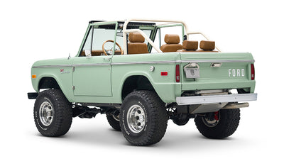 Rear and side view of green Classic Ford Bronco convertible showing tailgate with FORD lettering