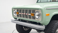 Close-up rear view of porcelain green Classic Ford Bronco displaying rear bumper and larger tires