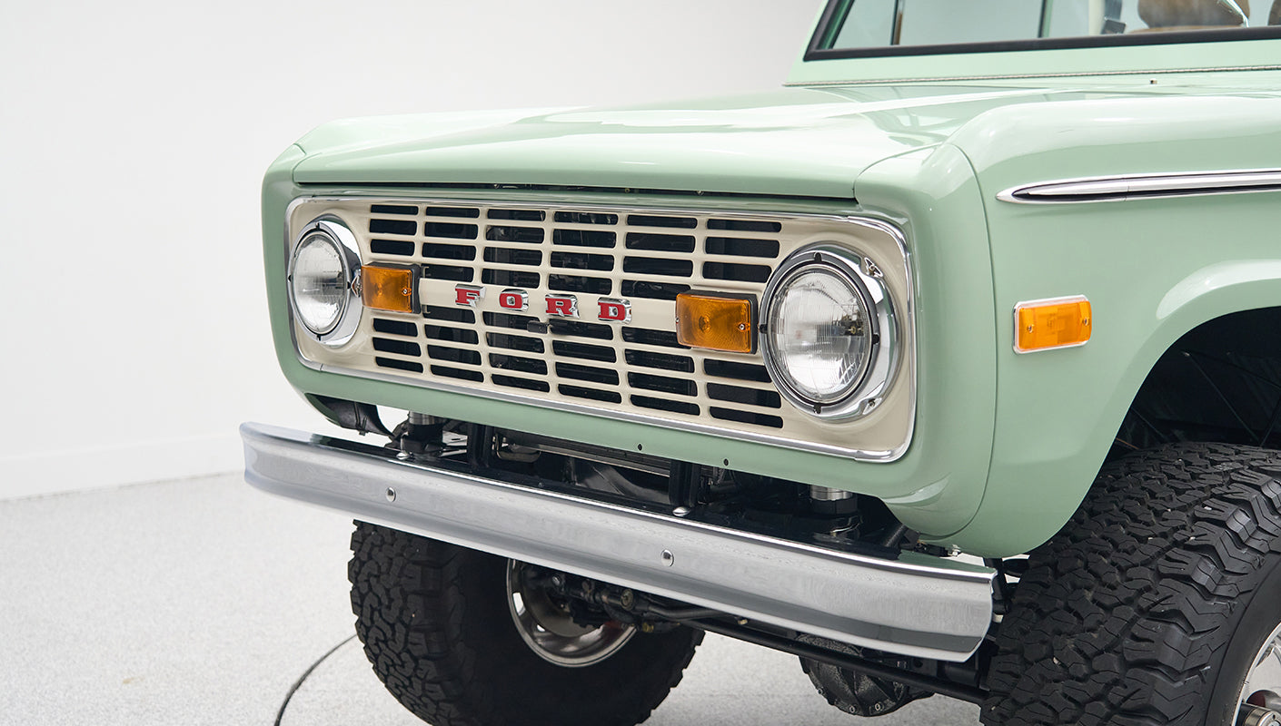 Close-up rear view of porcelain green Classic Ford Bronco displaying rear bumper and larger tires