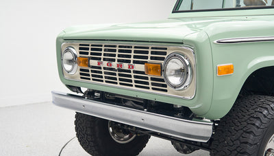 Close-up rear view of porcelain green Classic Ford Bronco displaying rear bumper and larger tires