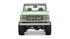 Front view of porcelain green Classic Ford Bronco showing grill, headlights, and lifted suspension