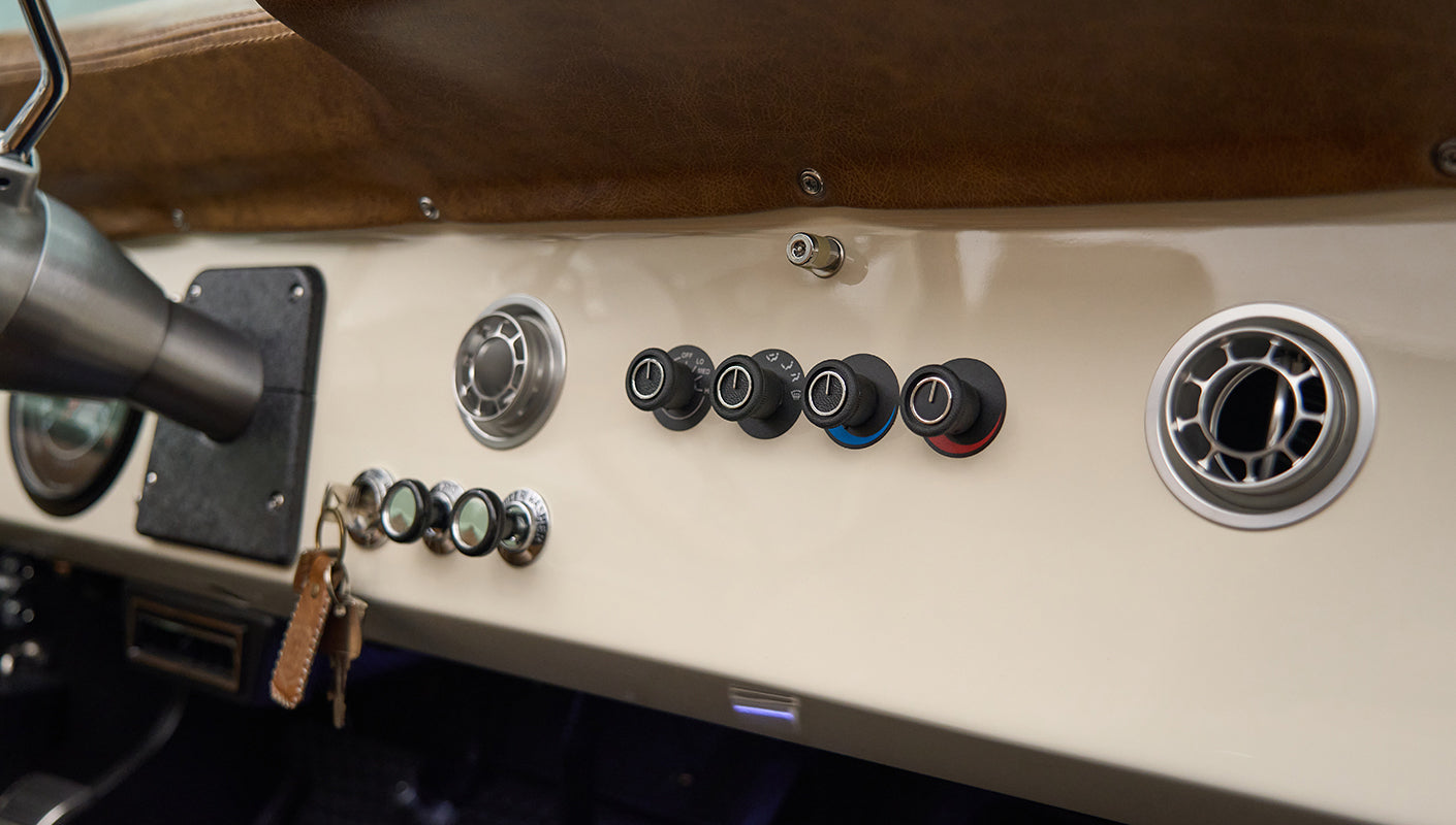 Dashboard controls and air vents in Classic Ford Bronco with cream colored panel and leather trim