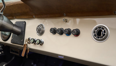 Dashboard controls and air vents in Classic Ford Bronco with cream colored panel and leather trim