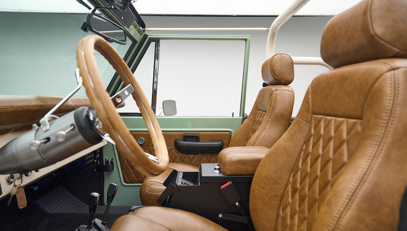 Interior view of Classic Ford Bronco with brown leather seats and porcelain green door panel