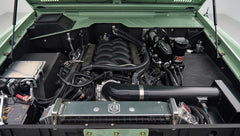 Close-up of Classic Ford Bronco engine compartment with green edges and multiple hoses