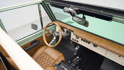 Classic Ford Bronco interior with tan leather seats, steering wheel and dashboard visible