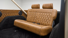 Rear bench seat with brown leather upholstery and diamond stitching in Classic Ford Bronco