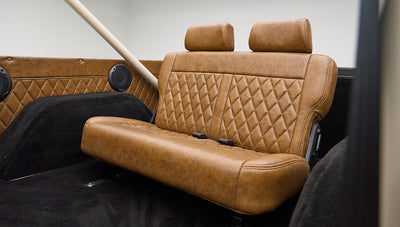 Rear bench seat with brown leather upholstery and diamond stitching in Classic Ford Bronco