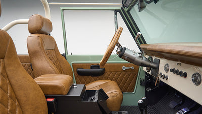 Side view of Classic Ford Bronco interior showing brown front seats and porcelain green door
