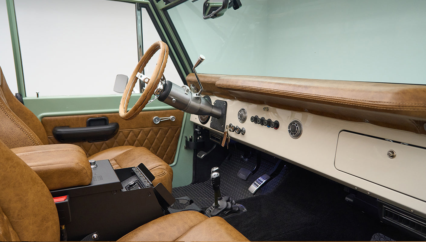 Classic Ford Bronco driver side interior with green exterior and tan leather seats
