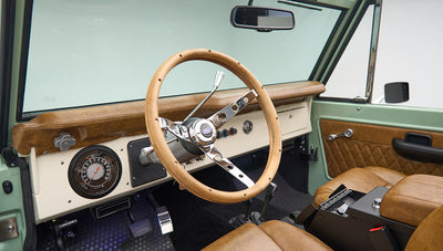 Driver seat and dashboard of Classic Ford Bronco with leather steering wheel and gauges