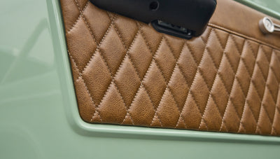 Close-up of brown diamond-stitched leather interior panel on green door