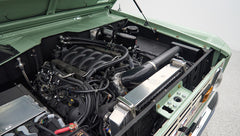 Classic Ford Bronco engine bay showing clean engine and green painted inside hood