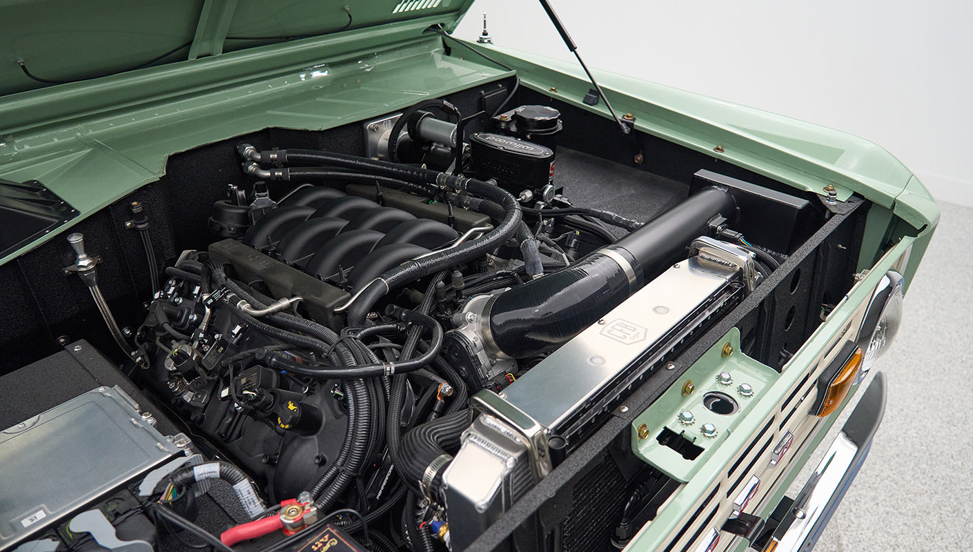 Classic Ford Bronco engine bay showing clean engine and green painted inside hood