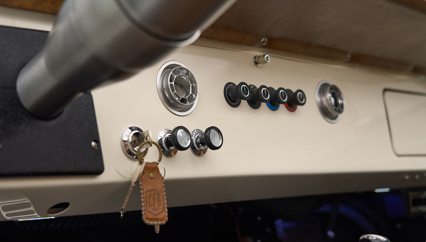 Close-up of control knobs and ignition key with leather keychain on Classic Ford Bronco dashboard