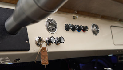 Close-up of control knobs and ignition key with leather keychain on Classic Ford Bronco dashboard