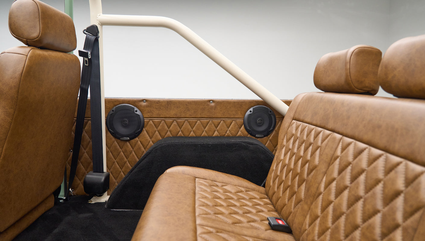Classic Ford Bronco interior rear seats, seat belts, and black speaker panels with brown leather trim