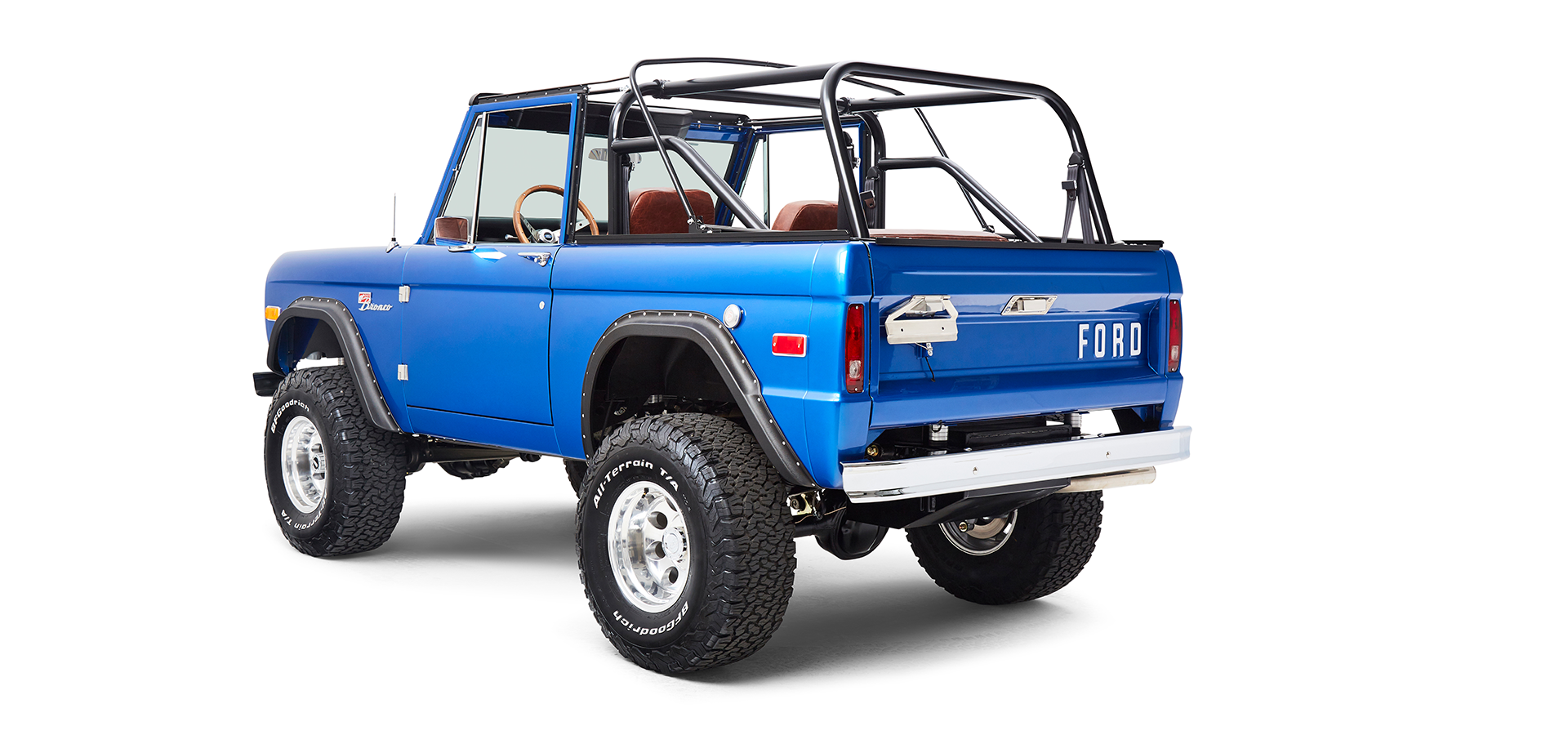 Classic Ford Bronco rear angled view in blue with off-road tires and open roll cage