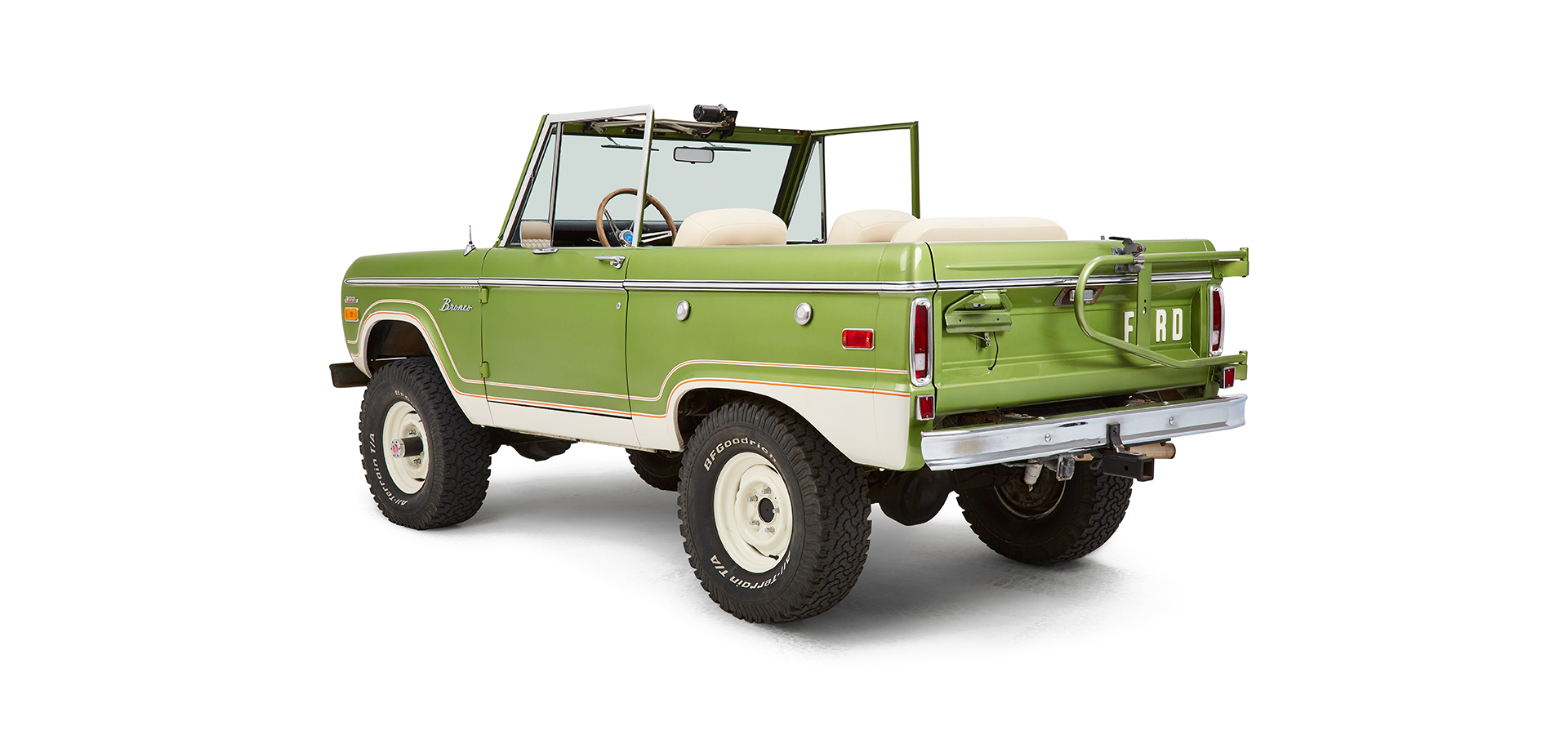 Rear driver angled view of green Classic Ford Bronco with open roof and visible interior
