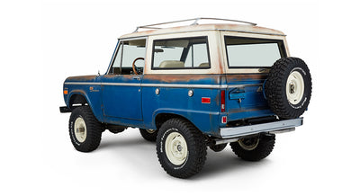 Classic Ford Bronco rear driver angled view showing body, spare tire, and wheels
