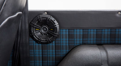 Close-up of car audio speaker and blue plaid fabric panel inside a Classic Ford Bronco interior