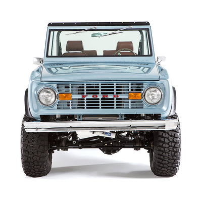 Close-up frontal view of light blue Classic Ford Bronco with large off-road tires