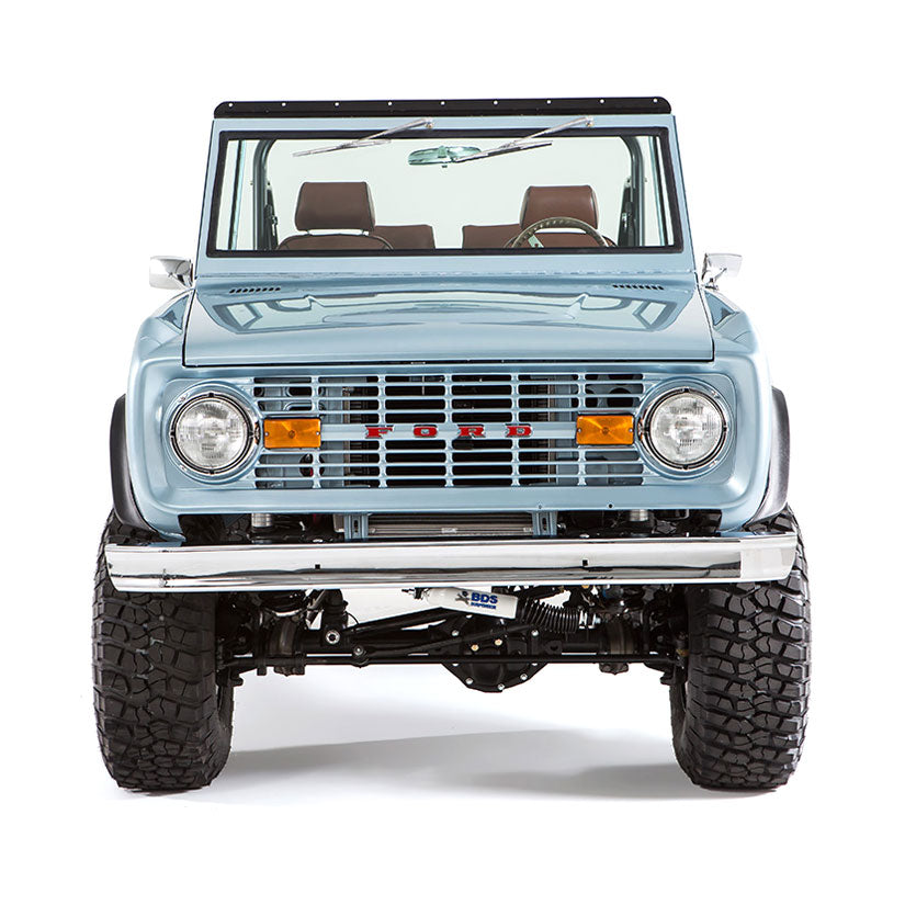 Close-up frontal view of light blue Classic Ford Bronco with large off-road tires