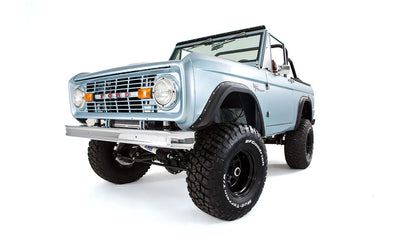 Front angled view of light blue Classic Ford Bronco showing grille and large tires