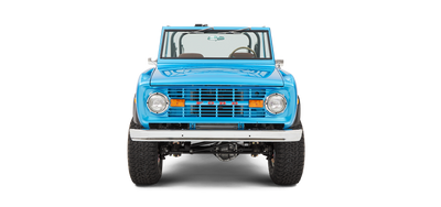 Front view of sky blue Classic Ford Bronco showing grille, headlights, and raised tires