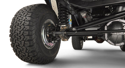 Close-up of front wheel, suspension, and steering linkage components under Classic Ford Bronco.