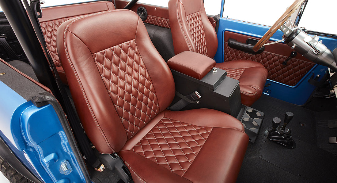Interior front seats of Classic Ford Bronco with brown quilted leather upholstery.