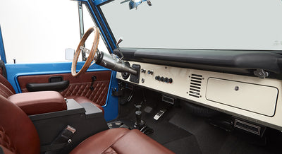 Dashboard and front seats inside sky blue Classic Ford Bronco with brown leather upholstery