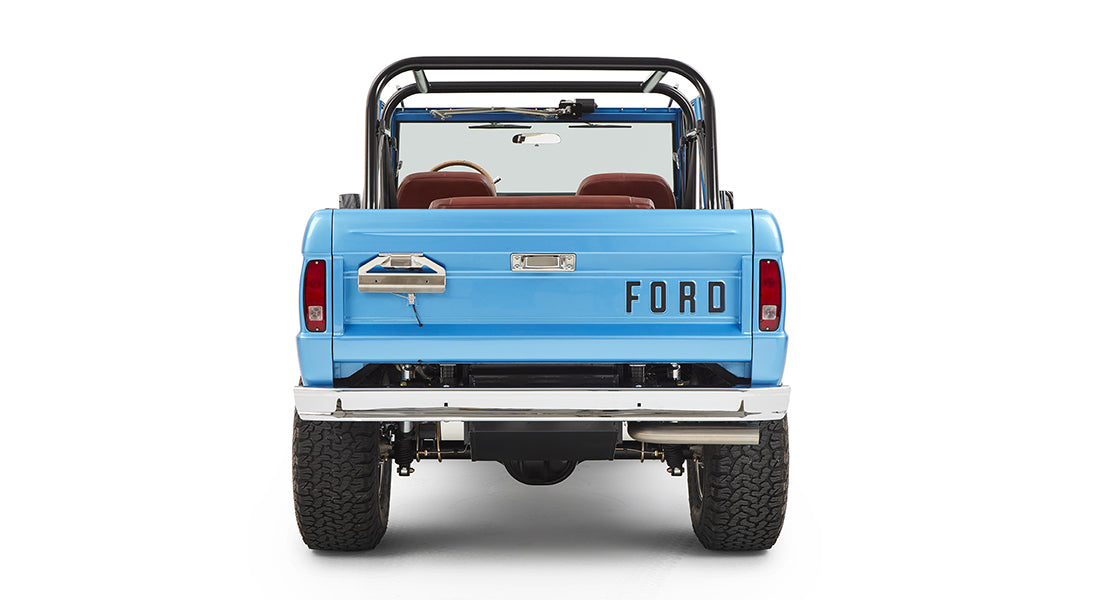 Rear view of sky blue Classic Ford Bronco with roll cage and FORD lettering on tailgate
