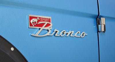 Close-up of Classic Ford Bronco emblem on sky blue vehicle door