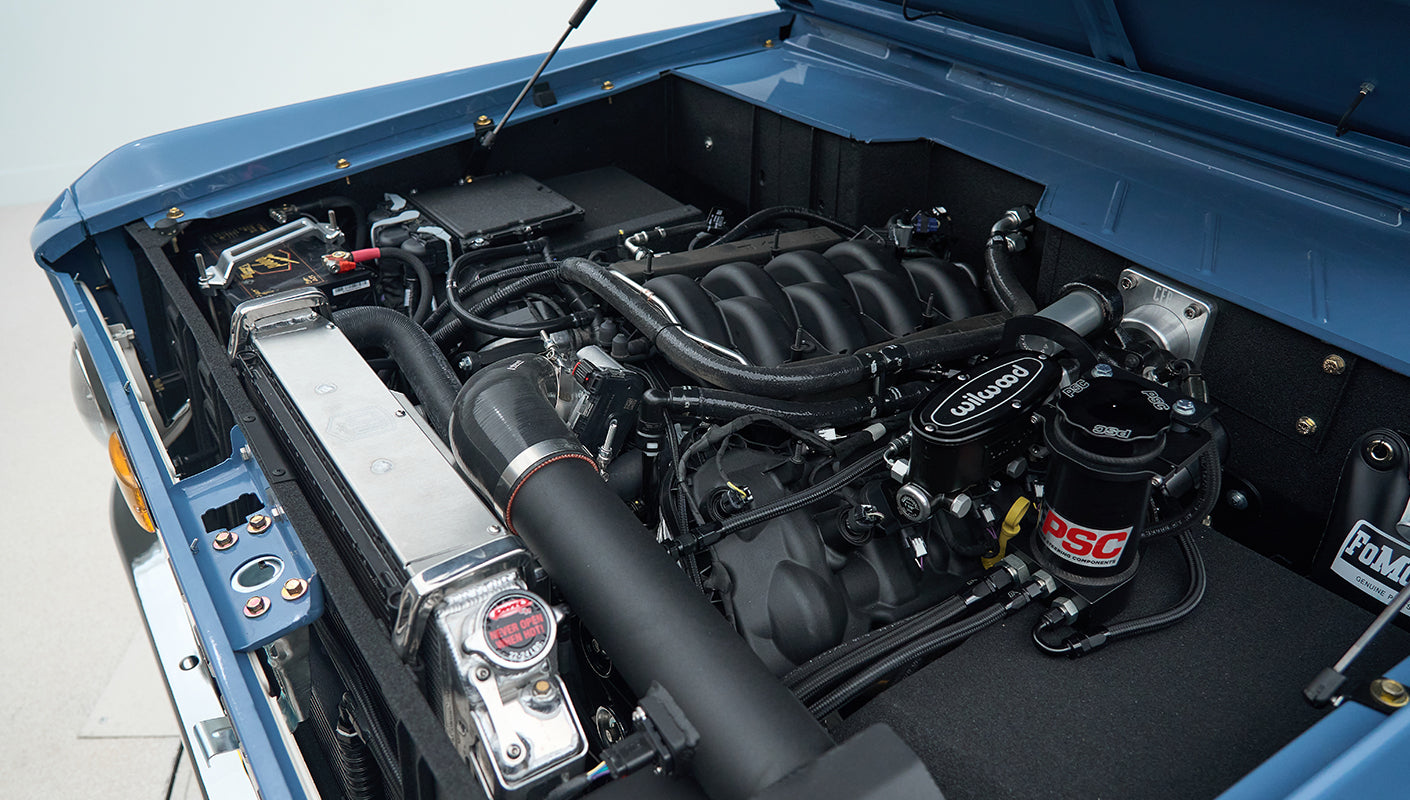 Detailed view of the Classic Ford Bronco's engine bay featuring a polished radiator and accessories.