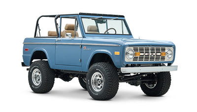 Blue Classic Ford Bronco angled front view with tan seats and black roll bar