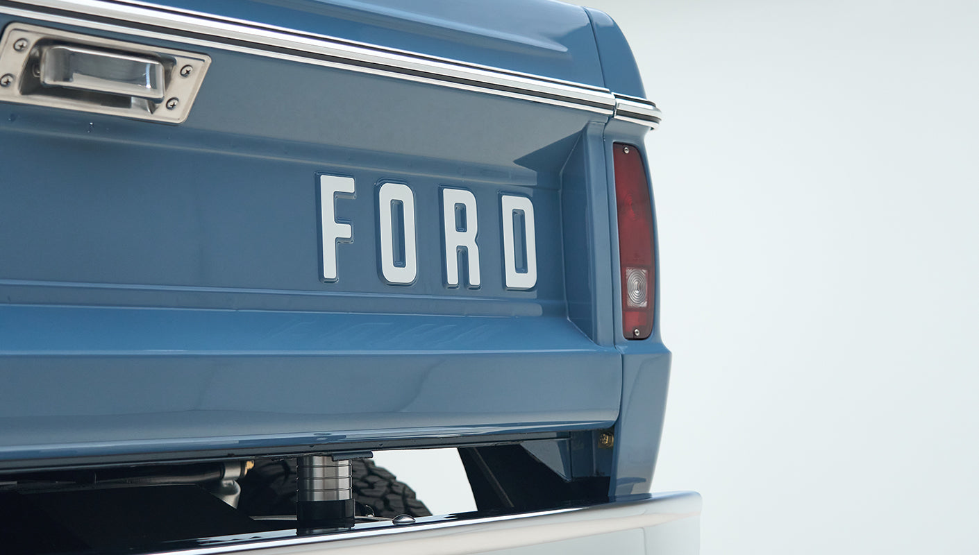 Rear end of blue Classic Ford Bronco with large FORD letters and taillight