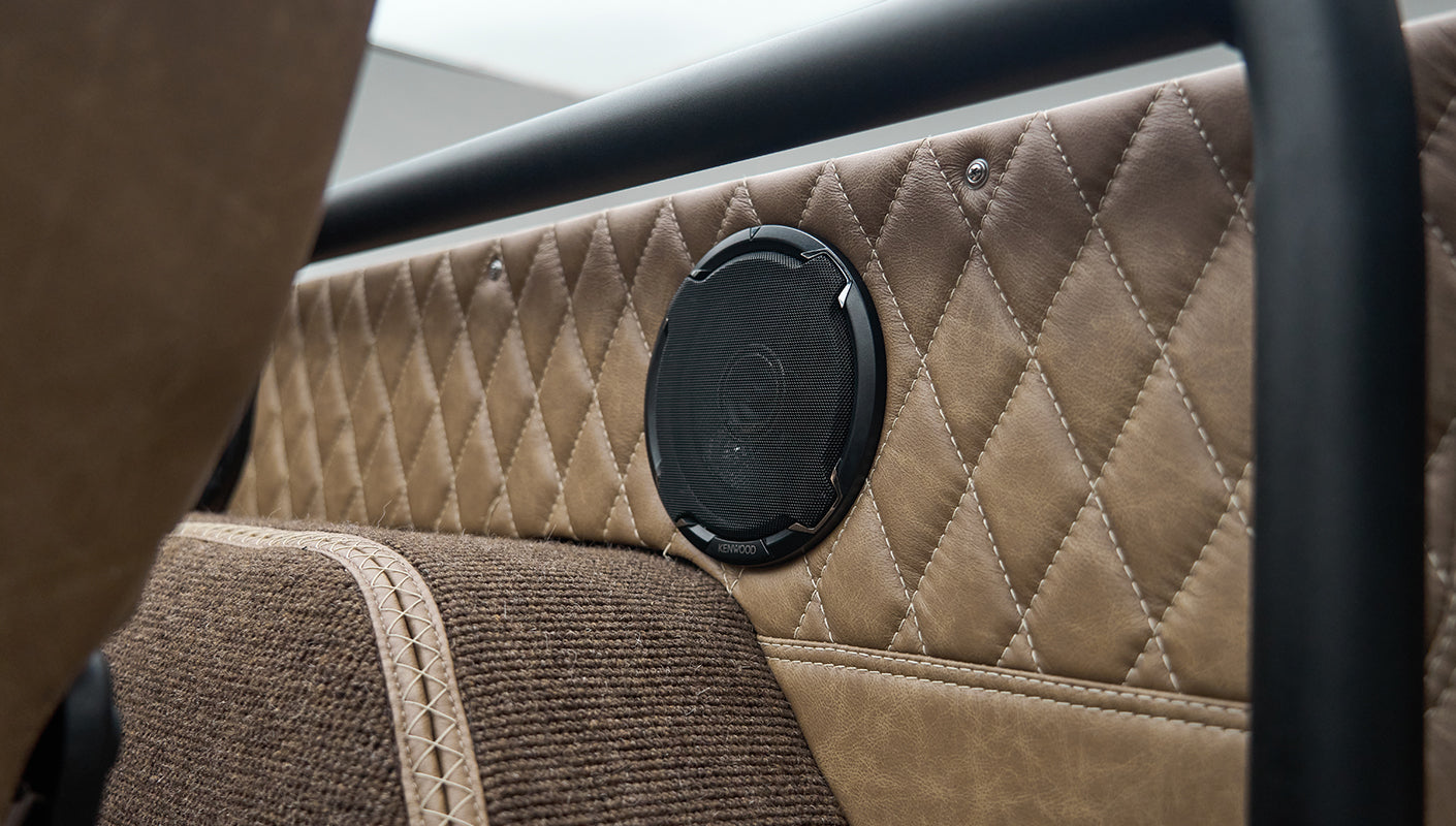 Close-up of speaker embedded in tan quilted interior panel of Classic Ford Bronco