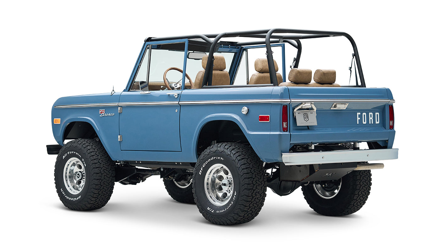 Blue Classic Ford Bronco rear angled view showing FORD lettering on tailgate and off-road tires